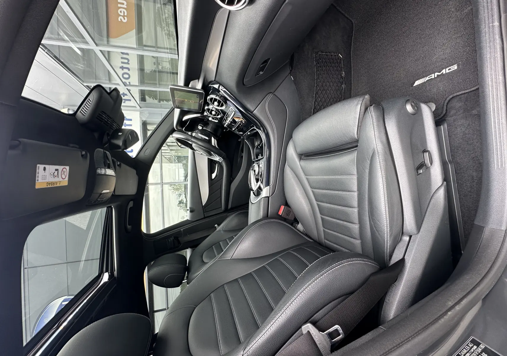 Intérieur noir du Mercedes GLC Coupé 250 D Fascination 4MATIC 2018, vue côté conducteur avec sièges cuir et tapis AMG.