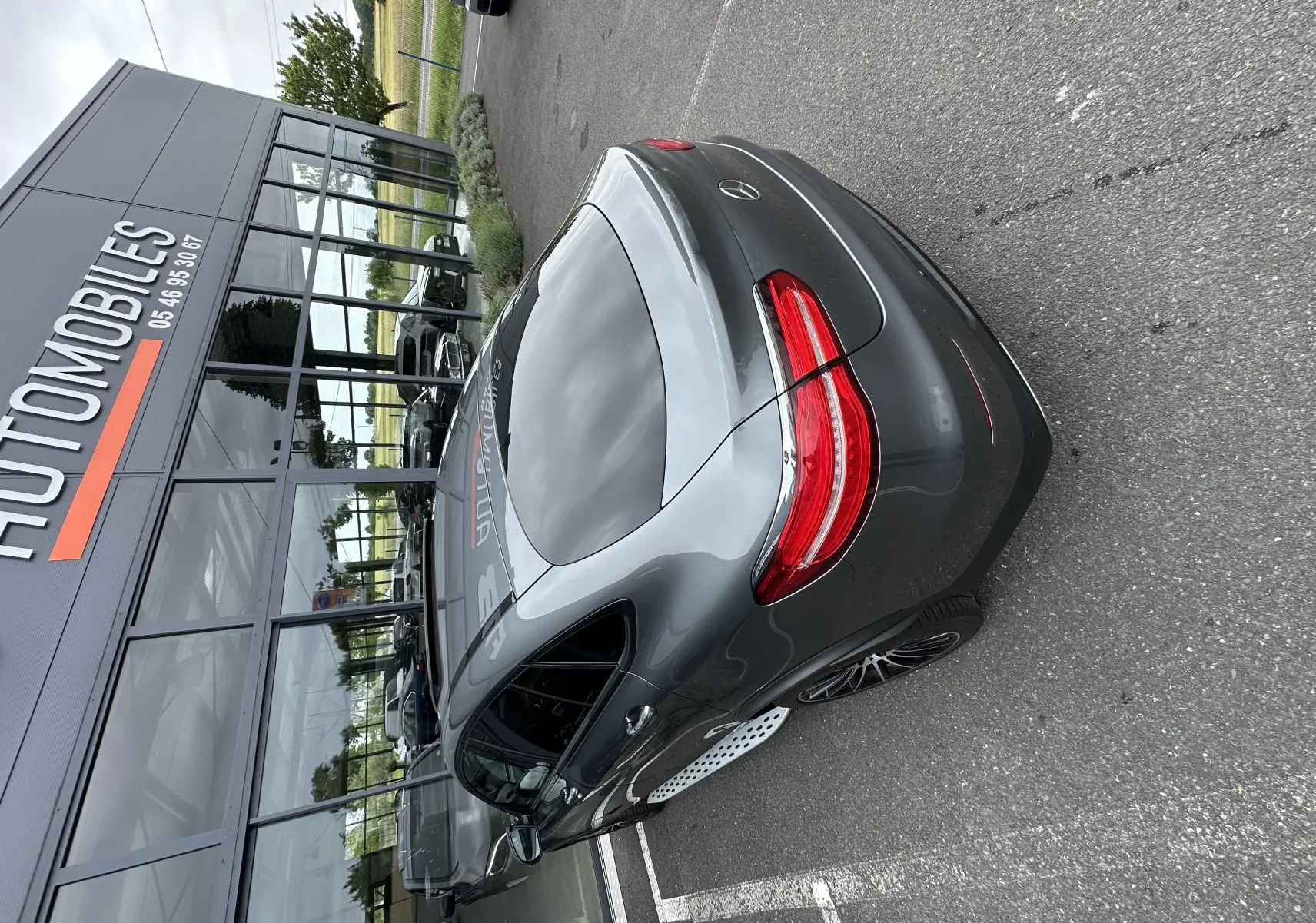 Mercedes GLC Coupé 250 D gris foncé vu en 3/4 arrière droit, avec feux arrière rouges et jantes sport noires.