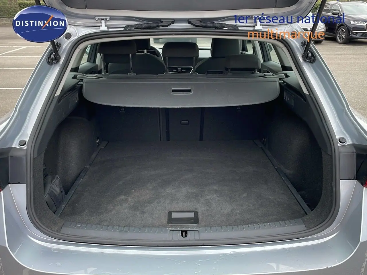 Coffre ouvert d'une SEAT LEON ST gris urbain 2023, vue arrière montrant l'espace de chargement vide et la plage arrière.