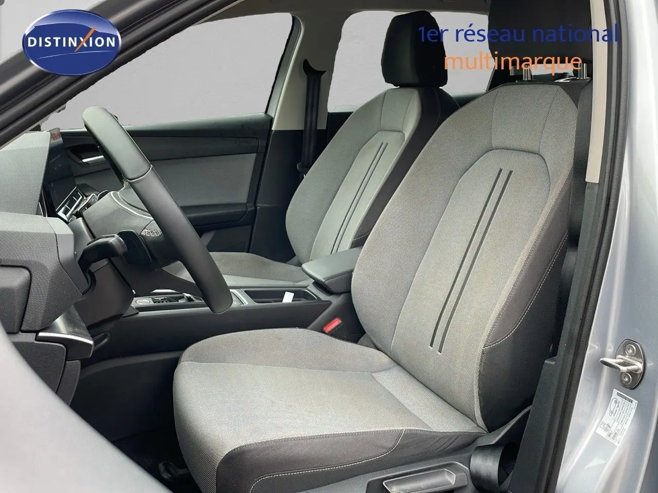 Intérieur côté conducteur du SEAT LEON ST gris urbain 2023, montrant sièges tissu gris et tableau de bord moderne.