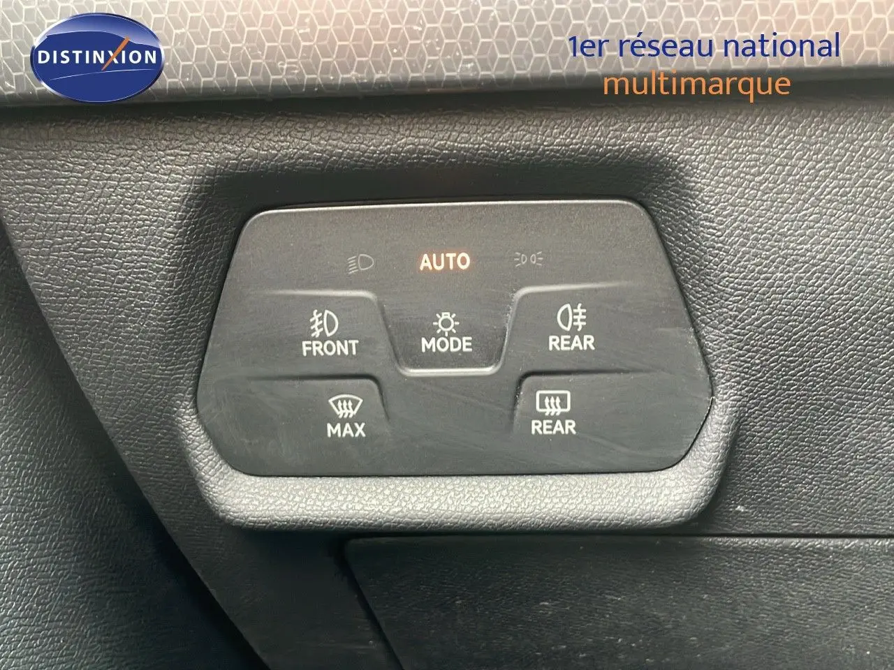 Gros plan sur les commandes d'éclairage et de désembuage du tableau de bord d'une SEAT LEON ST gris urbain 2023.