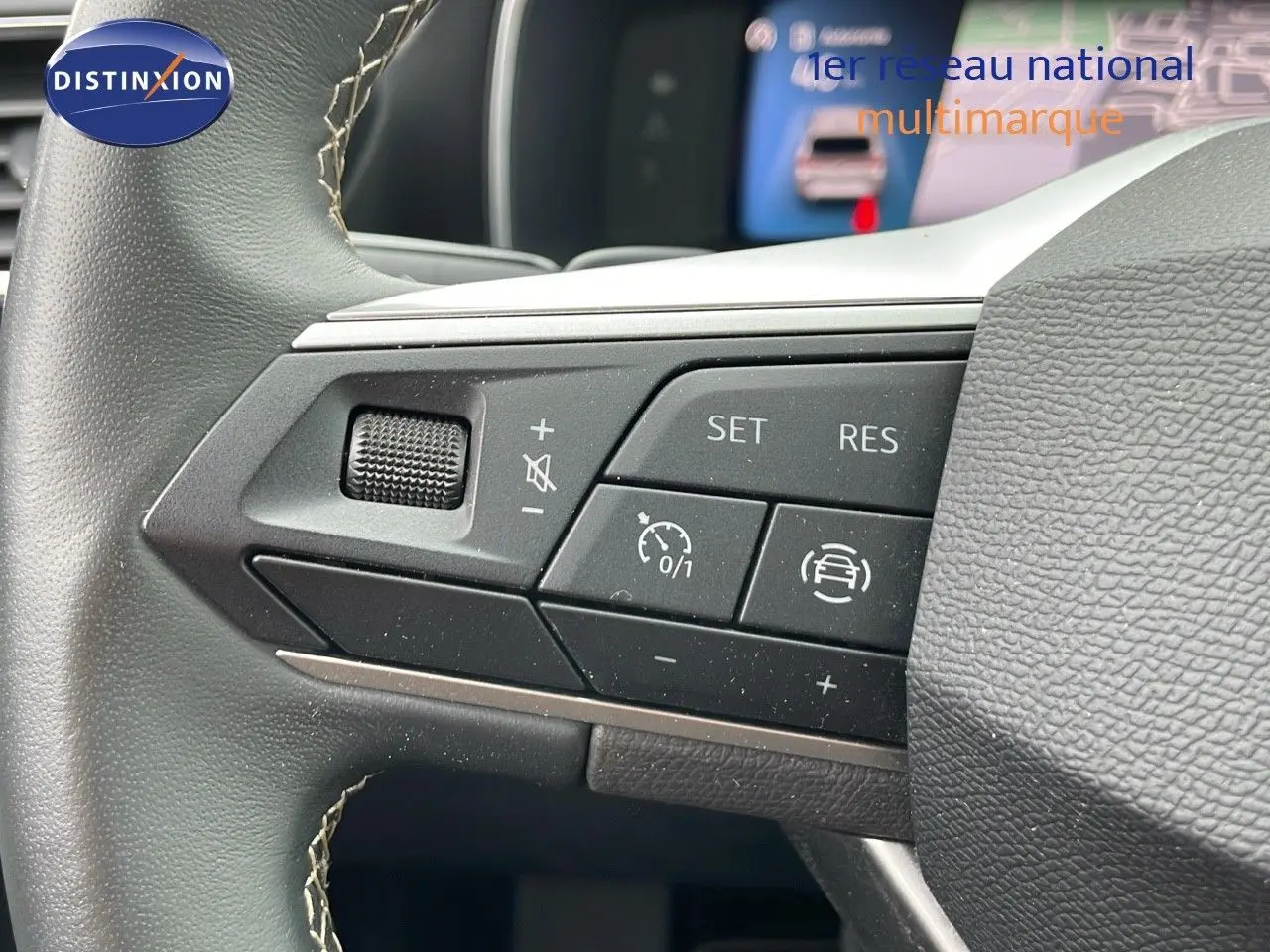 Gros plan sur les commandes au volant gauche de la SEAT LEON ST gris urbain 2023 avec régulateur de vitesse et assistance conduite.