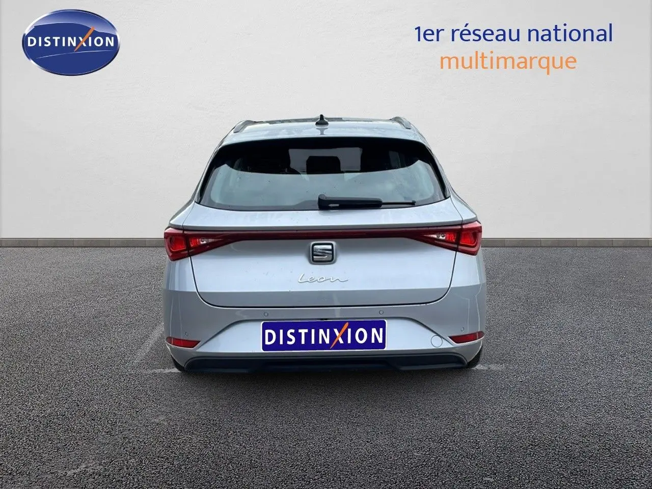 Vue arrière d'une SEAT LEON ST 2023 gris urbain, mettant en valeur ses feux arrière étirés et son hayon élégant.