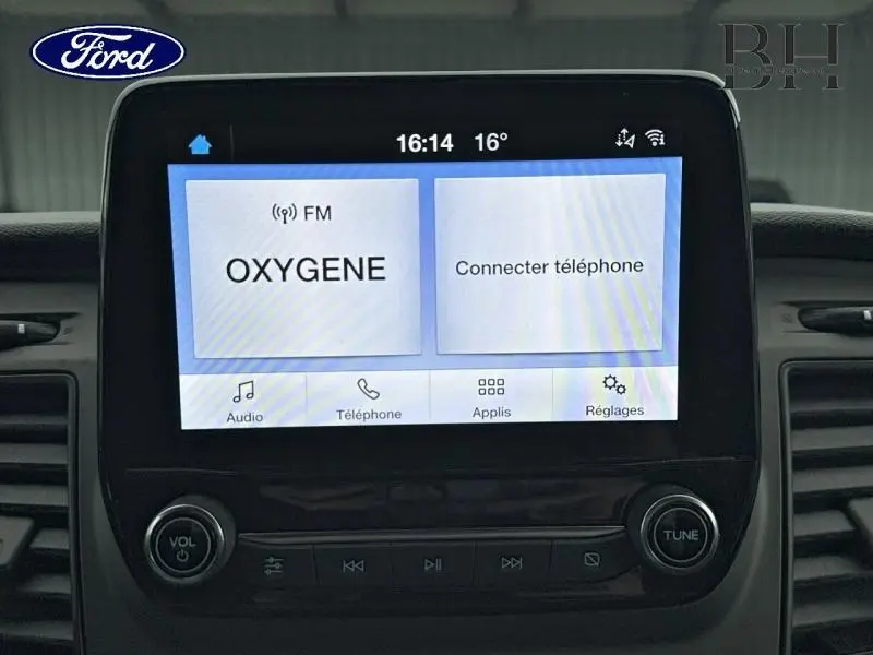 Écran tactile central du Ford Transit Custom noir affichant la radio FM et la connexion téléphone.