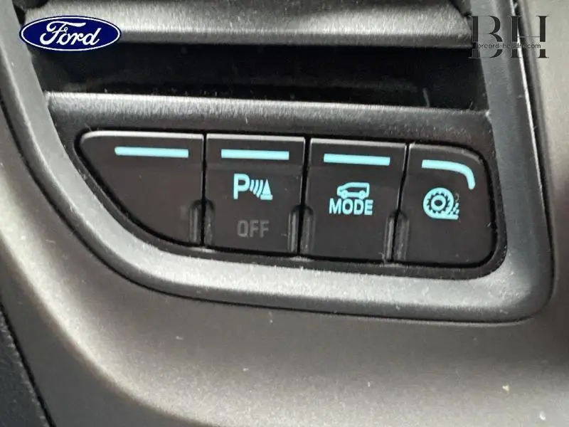Gros plan sur les boutons de commande du Ford Transit Custom noir, avec mode parking et réglage de traction visibles.