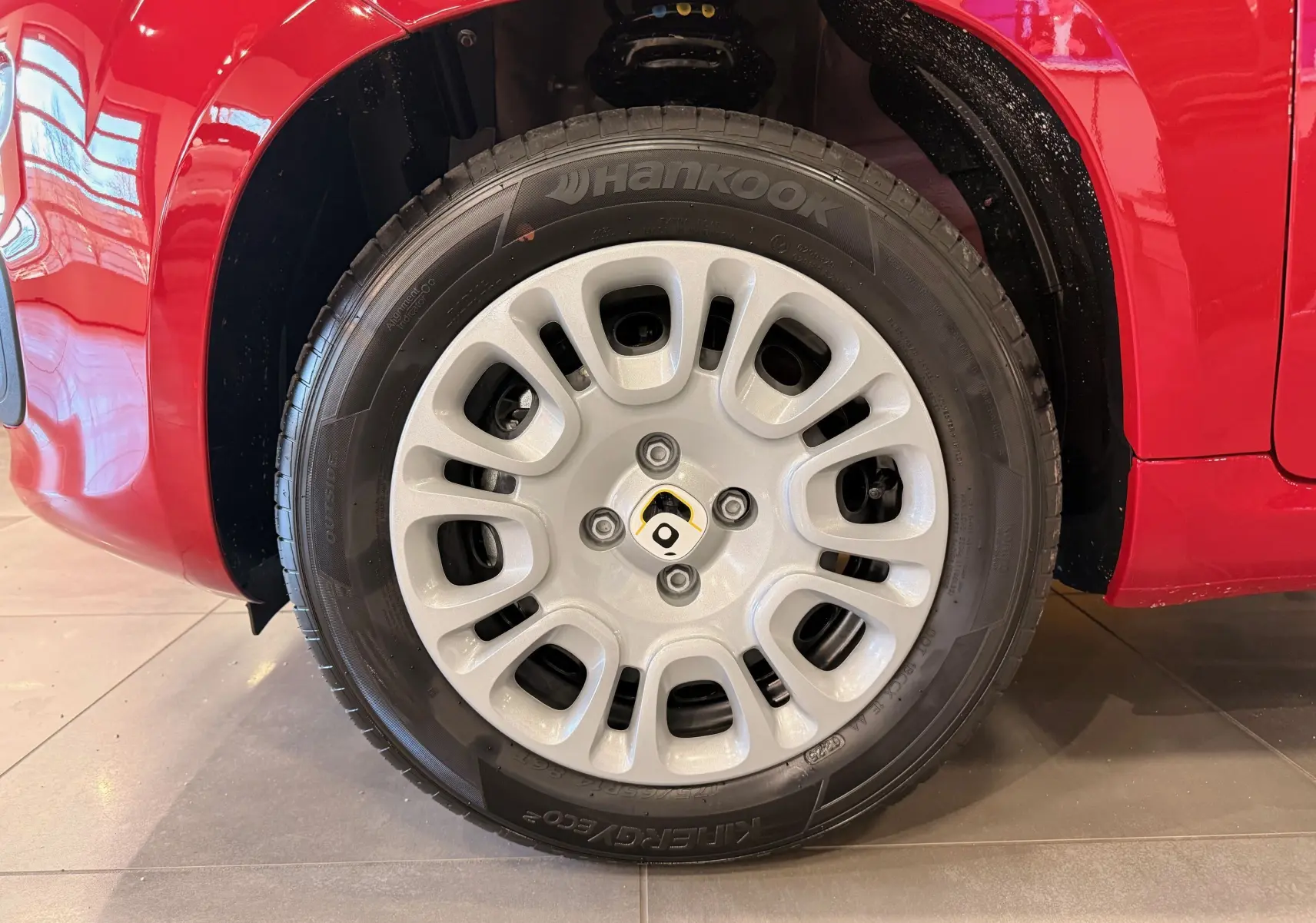 Gros plan sur la roue avant droite d'une FIAT Panda Rouge Amore, mettant en valeur la jante et le pneu Hankook.