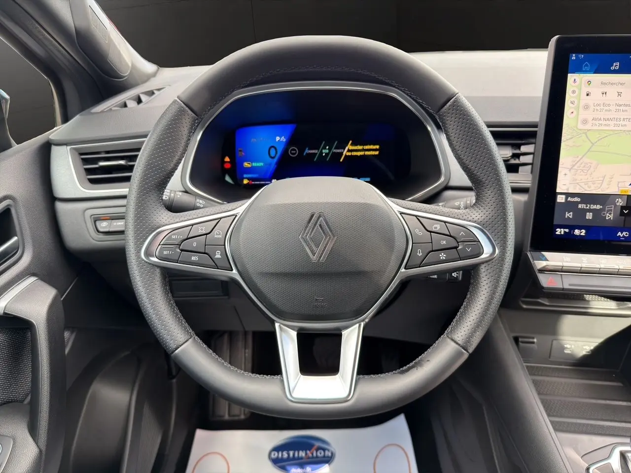 Vue rapprochée du volant noir perforé et du tableau de bord numérique du Renault Symbioz 2025 hybride.