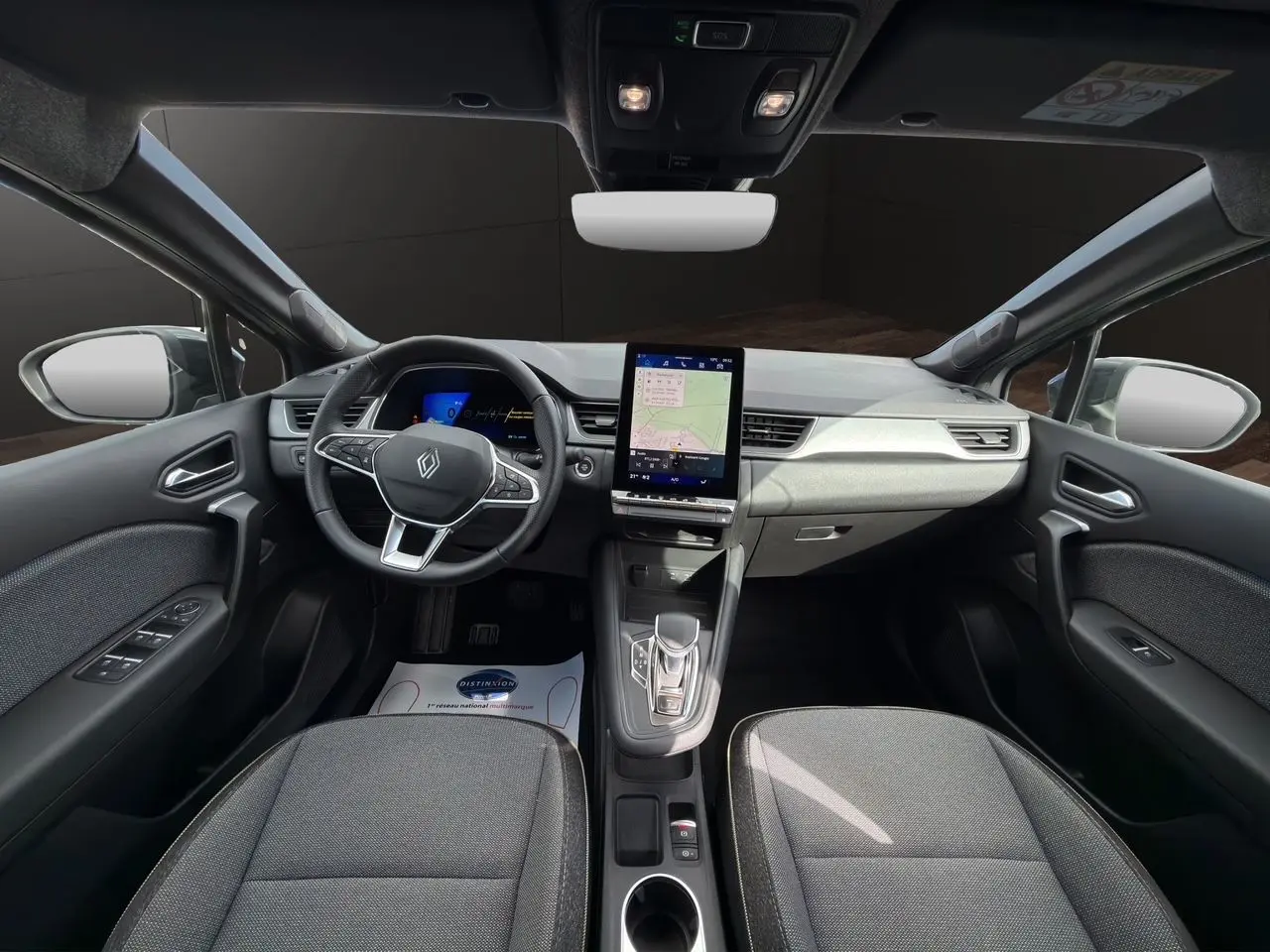 Vue intérieure avant du Renault SYMBIOZ gris clair, avec tableau de bord digital et écran tactile central vertical.
