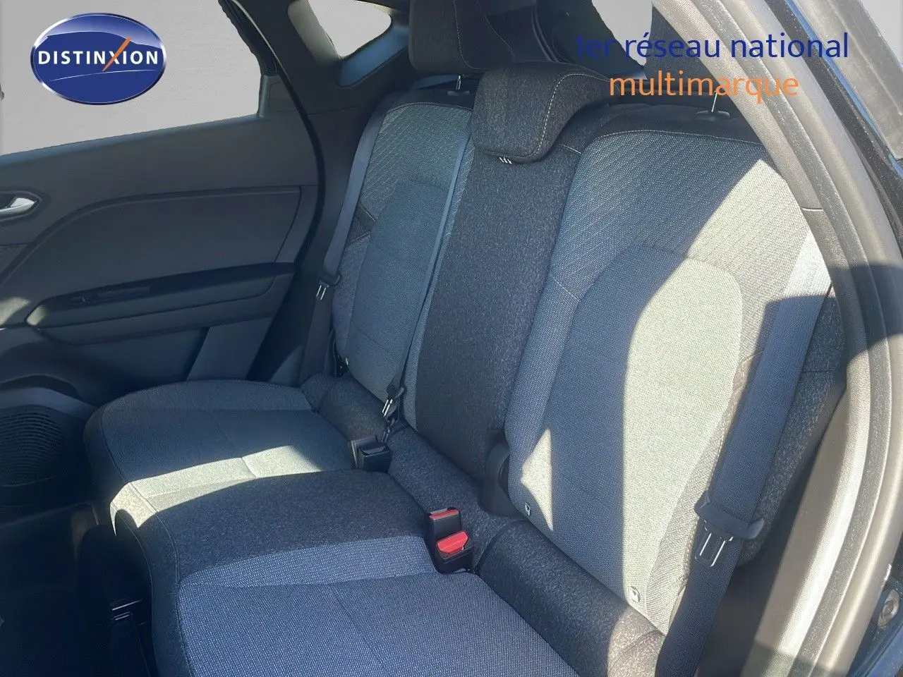 Vue intérieure des sièges arrière en tissu gris et noir du Renault Captur E-Tech hybride 2025, côté droit éclairé par le soleil.