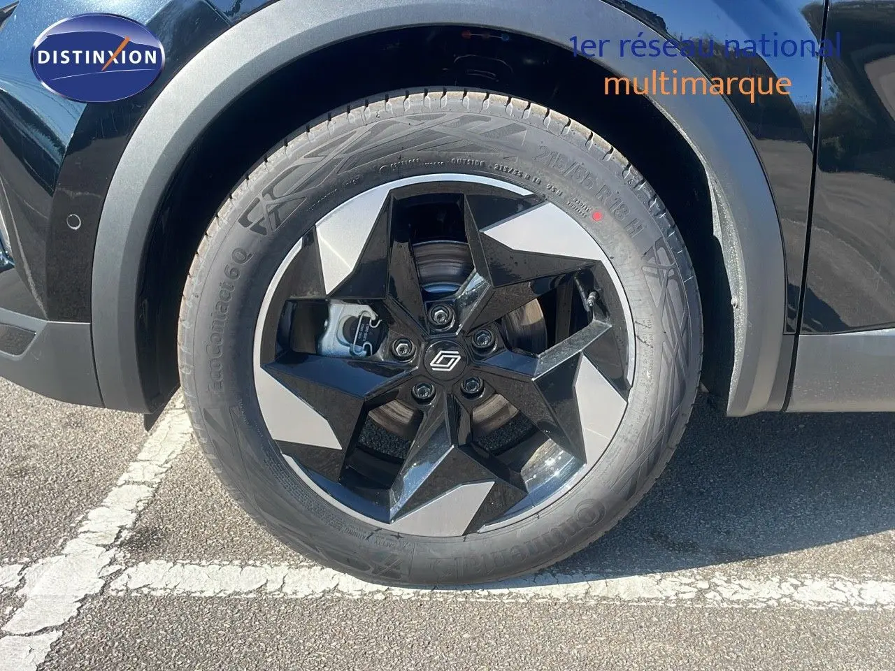 Gros plan sur la roue avant gauche du Renault Captur noir étoile métal, mettant en valeur la jante noire et argentée au design étoilé.