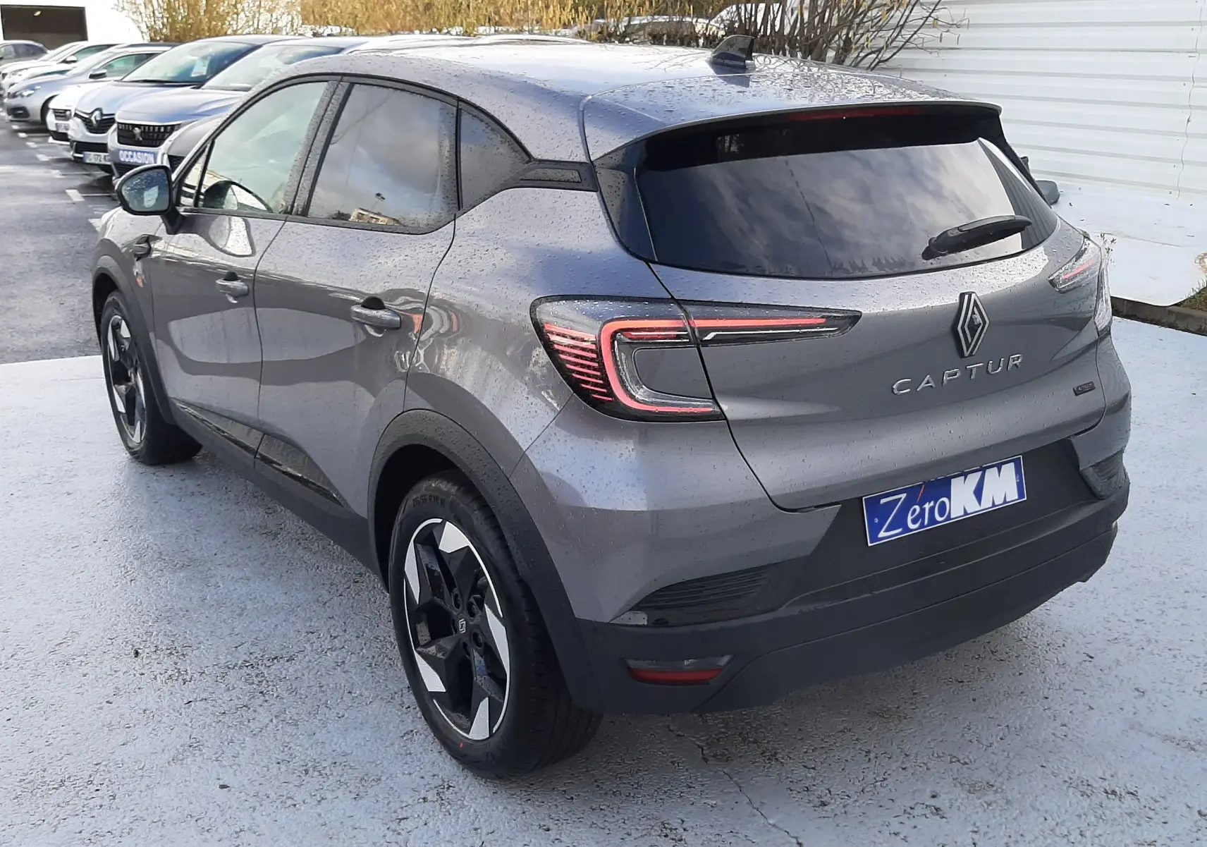 Vue 3/4 arrière droite d'un Renault Captur gris Cassiopée 2025 avec feux LED et jantes bi-ton.