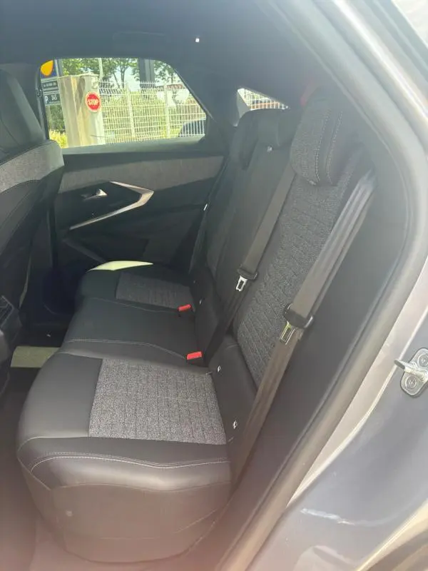 Vue intérieure côté droit des sièges arrière en tissu gris et cuir noir du Peugeot 3008 Hybrid 136 e-DCS6 Allure 2025 gris clair.