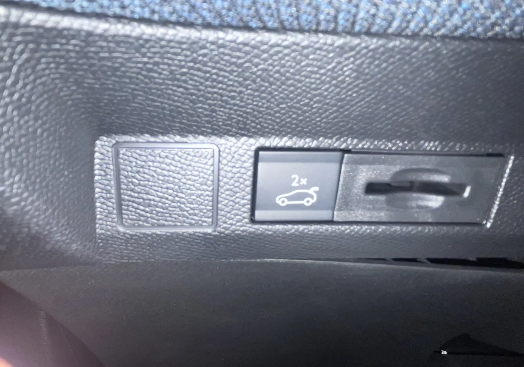 Gros plan sur le bouton d'ouverture du coffre dans l'habitacle du Citroën C5 Aircross hybride 2026.
