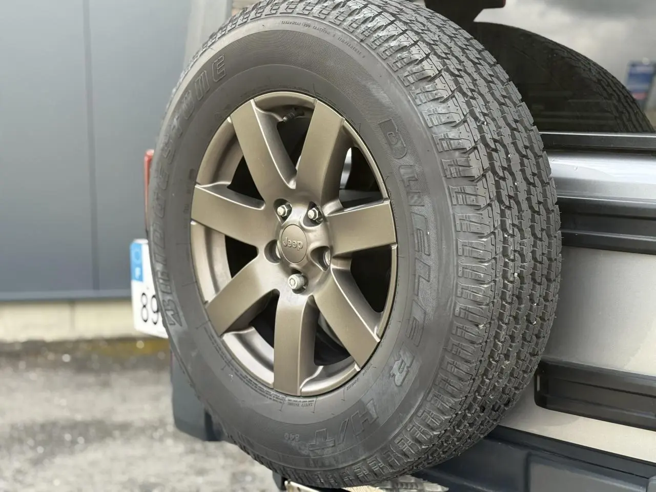 Gros plan sur la roue de secours Billet Silver du Jeep Wrangler 2.8 CRD 200 Unlimited Golden Eagle à l'arrière droit.