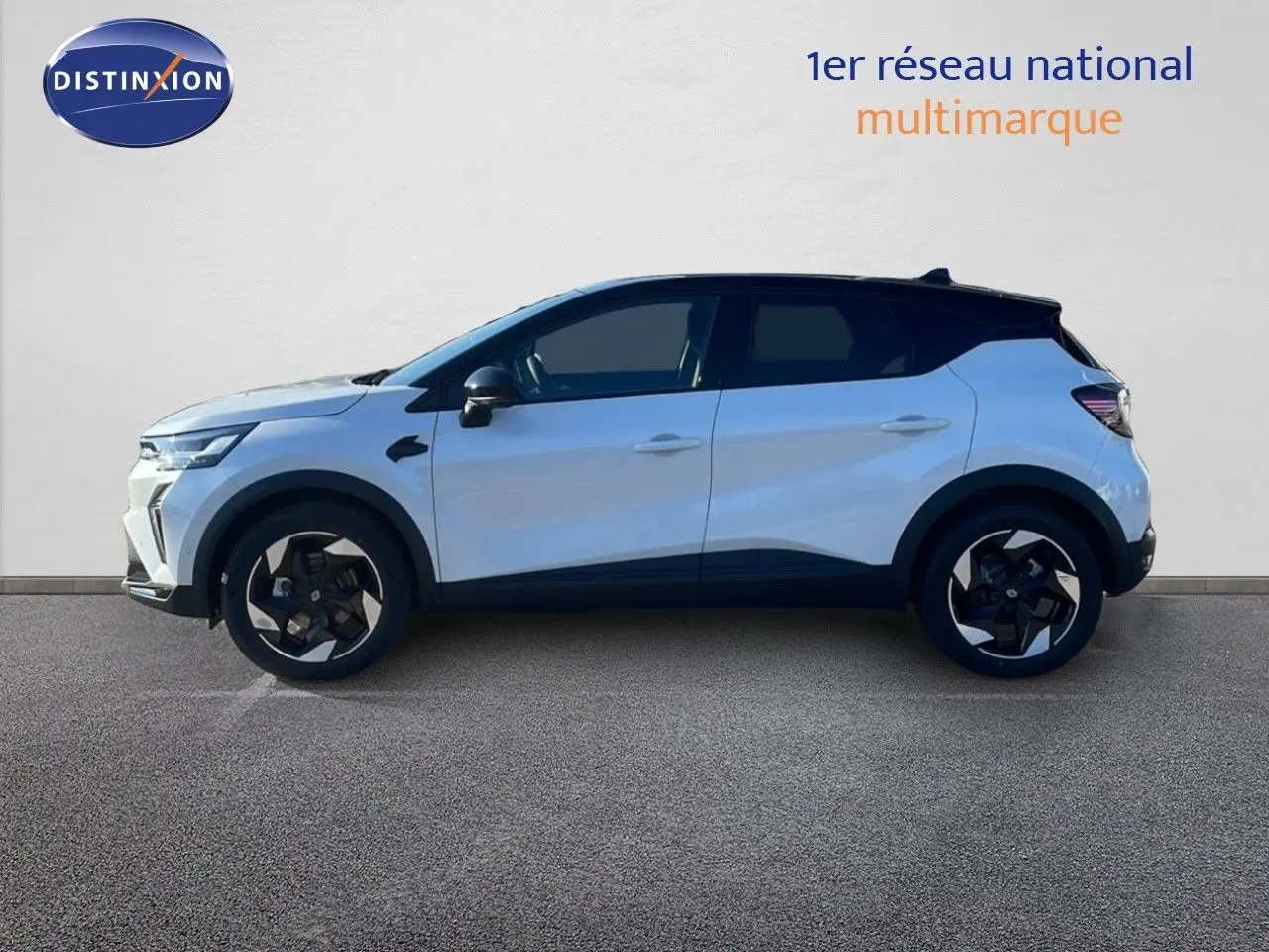 Profil côté gauche du Renault Captur E-Tech hybride 2025 blanc nacré avec toit noir et jantes noires distinctives.