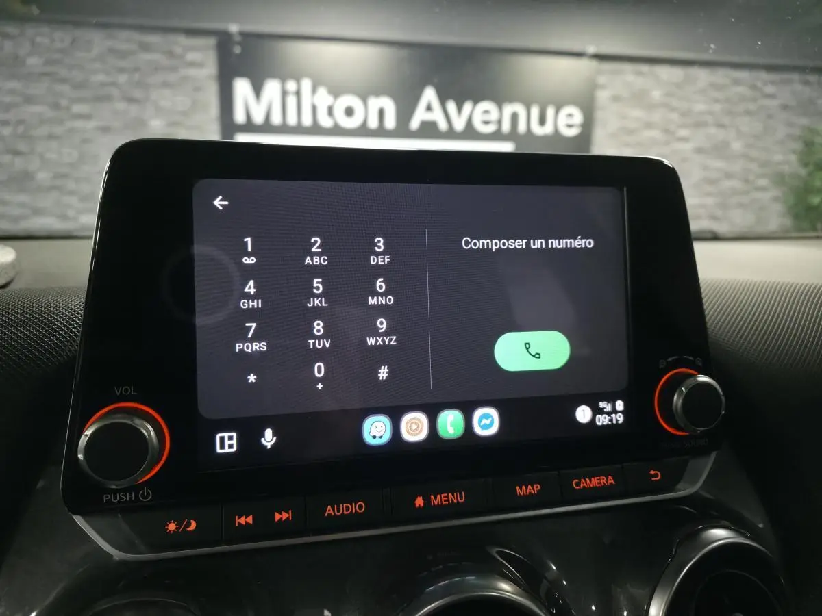Écran tactile central du tableau de bord du Nissan Juke 2023 affichant le composeur téléphonique en intérieur noir.