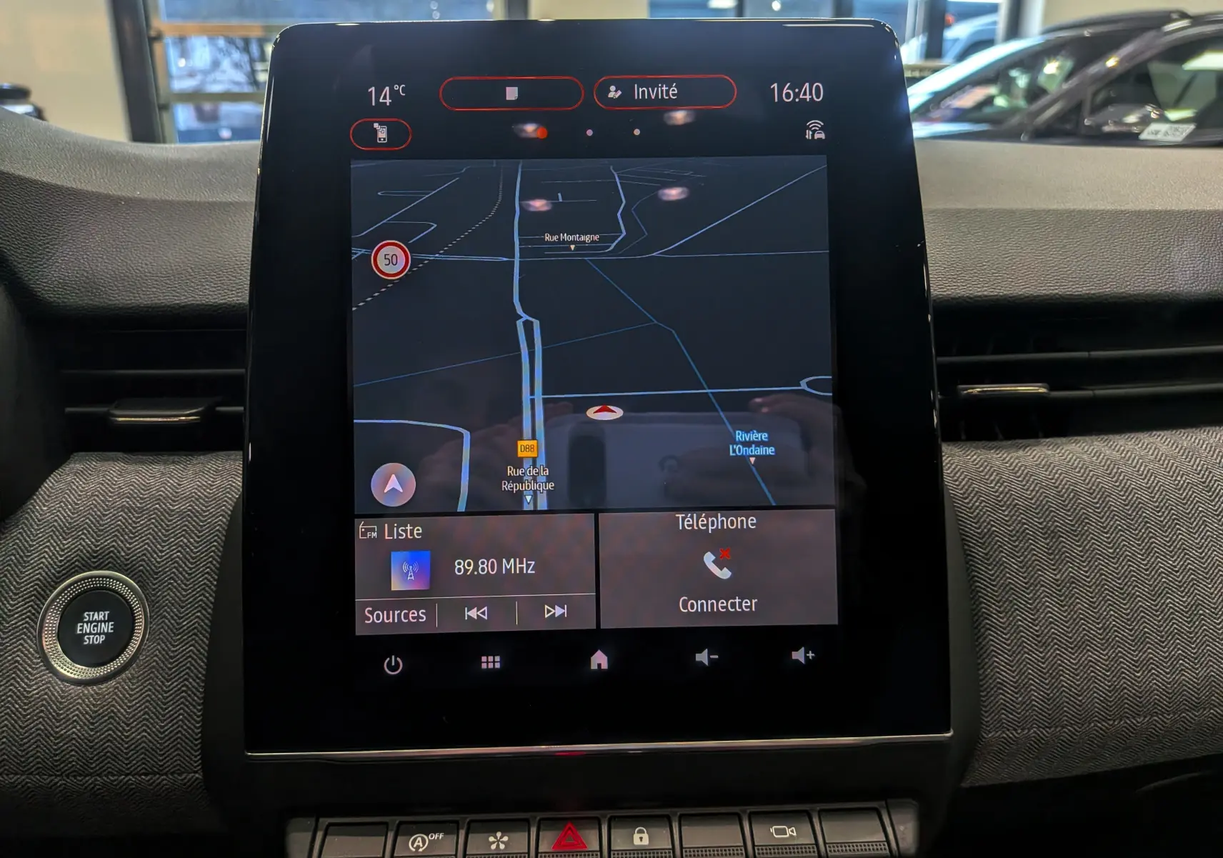 Écran tactile central de la Renault Clio V affichant la navigation et les commandes multimédia, avec bouton Start Engine Stop visible.