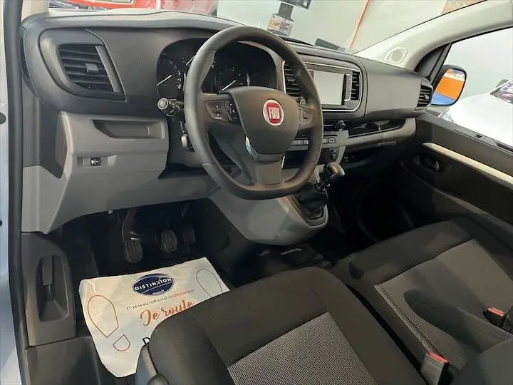 Vue intérieure côté conducteur du Fiat Scudo cabine approfondie 2022 avec volant multifonction et sièges tissu gris.