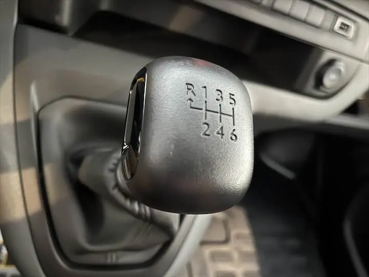 Gros plan sur le levier de vitesse manuel gris du FIAT Scudo Cabine Approfondie 2022, six rapports visibles.