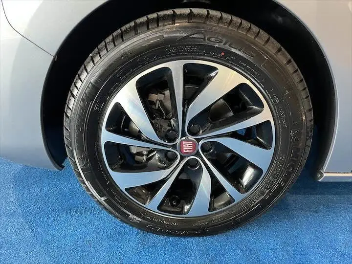 Gros plan sur la roue avant droite gris artensé métal du Fiat Scudo cabine approfondie avec jante noire et argentée.