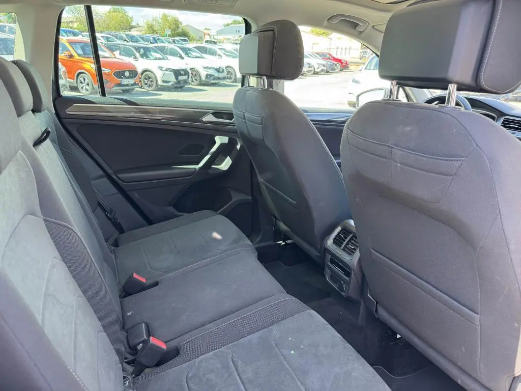 Vue intérieure arrière côté gauche du Volkswagen Tiguan 2.0 TDI 150 DSG 7 Elegance avec sellerie microfleece gris et aérateurs centraux.