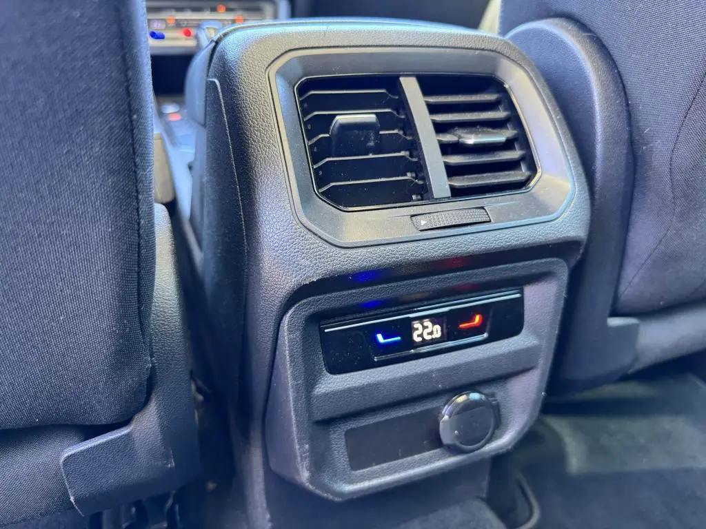 Vue rapprochée de la console arrière avec ventilation et réglage climatisation à 22°C dans un Volkswagen Tiguan gris.