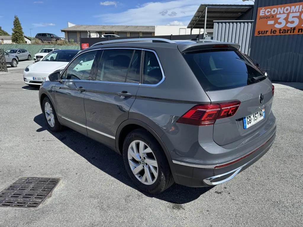 Vue 3/4 arrière droite d'un Volkswagen Tiguan gris Urano avec feux arrière LED et jantes alliage 18 pouces.