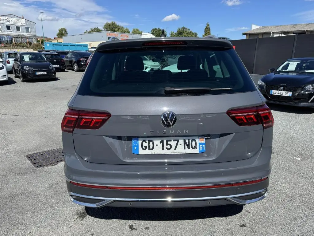 Vue arrière d'un Volkswagen Tiguan gris avec feux arrière LED et plaque d'immatriculation française visible.