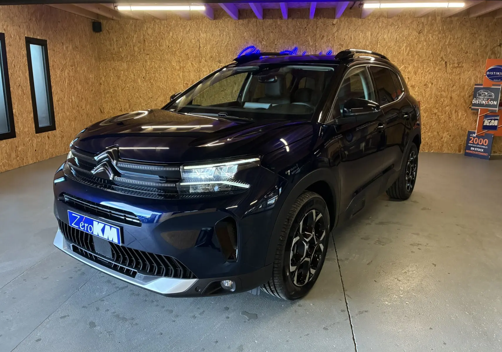 Vue 3/4 avant droite du Citroën C5 Aircross bleu Eclipse Métal avec calandre distinctive et jantes bi-ton.