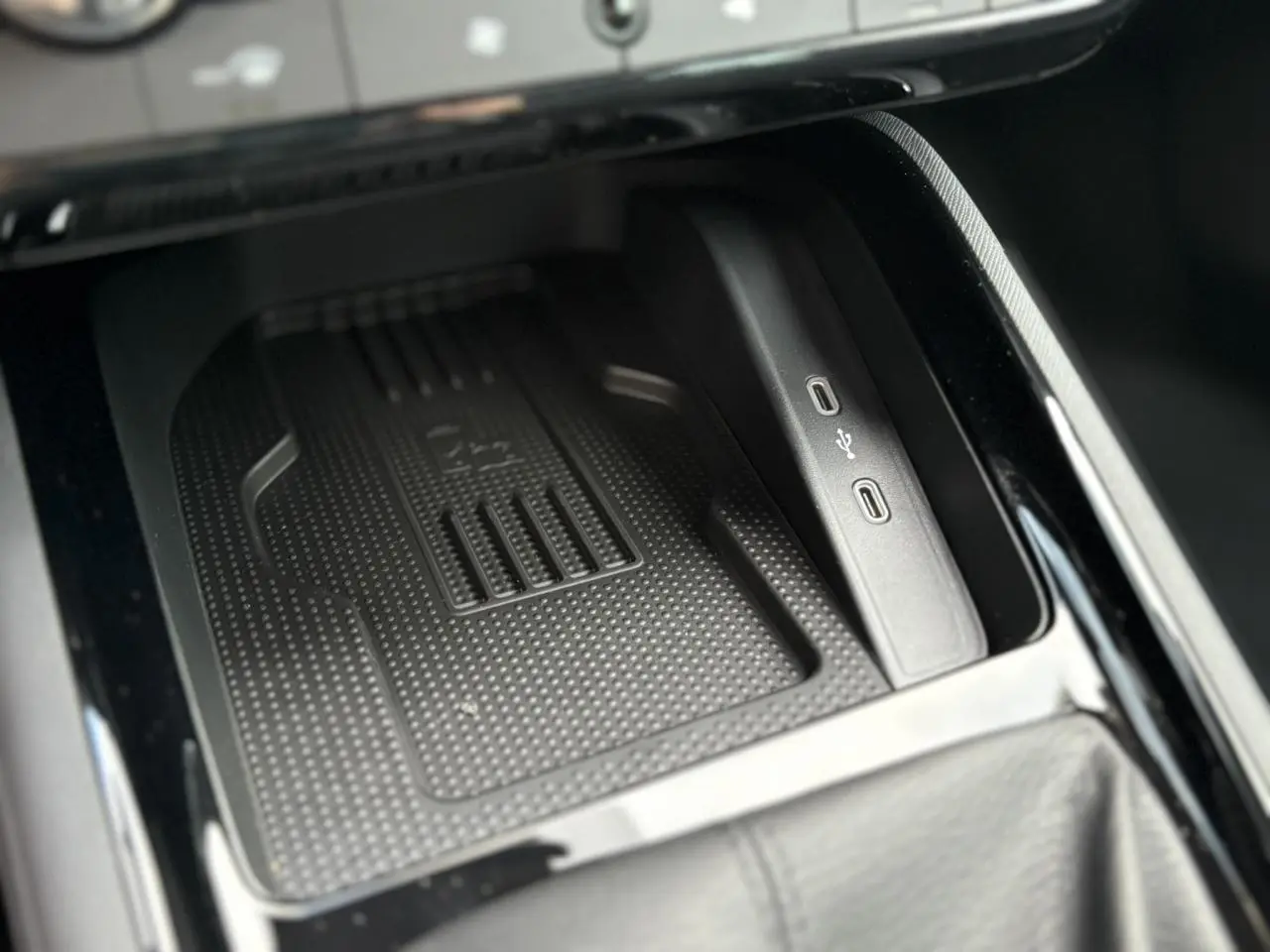 Gros plan sur le compartiment de rangement avec chargeur induction et ports USB-C du Skoda Kamiq gris argent 2025.