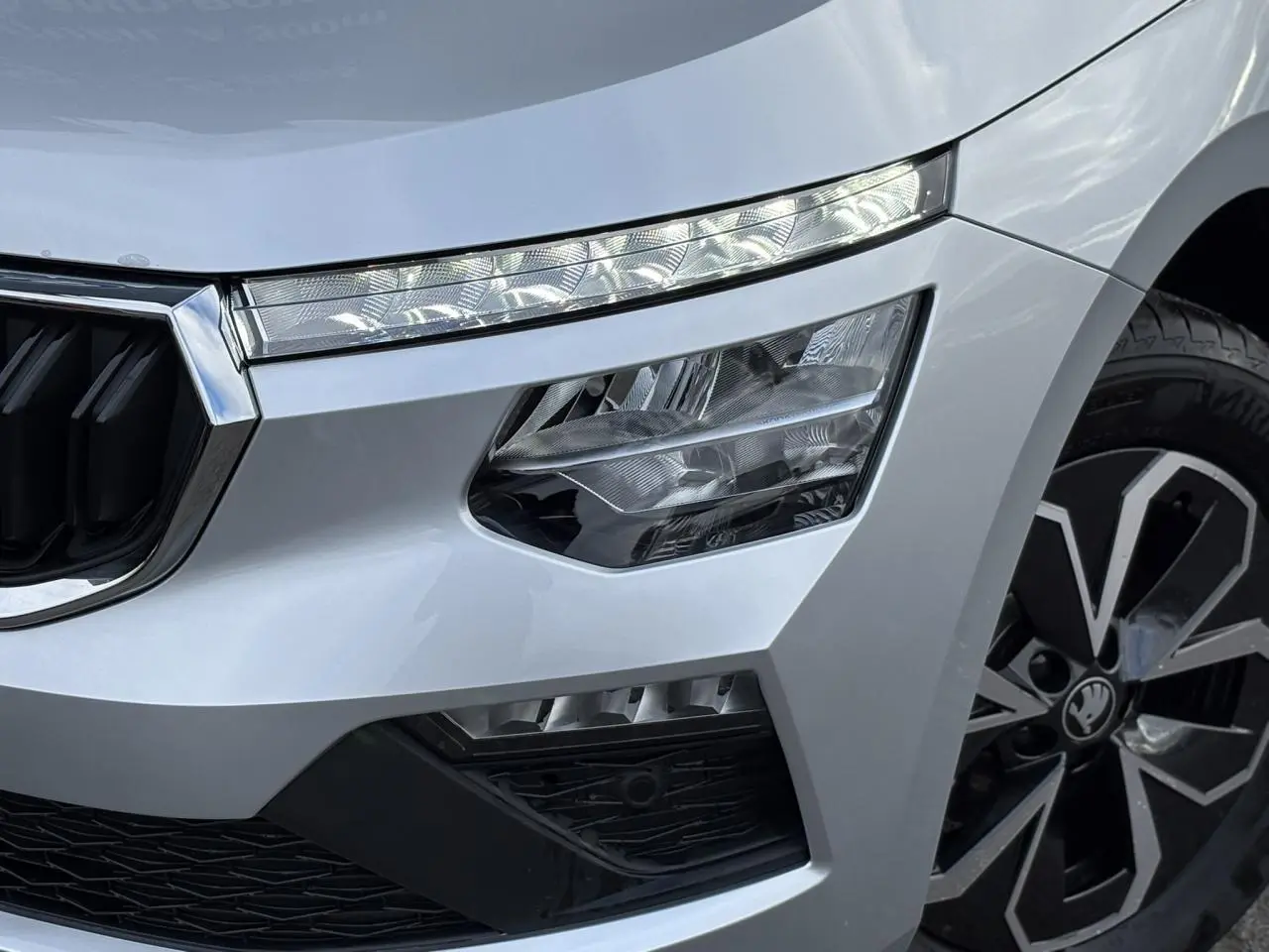 Gros plan sur l'avant droit gris argent du Skoda Kamiq 2025, mettant en valeur les phares Full LED et la jante alliage.