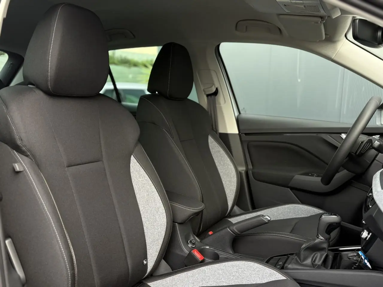 Vue intérieure côté droit montrant les sièges avant bicolores noirs et gris du Skoda Kamiq 2025.