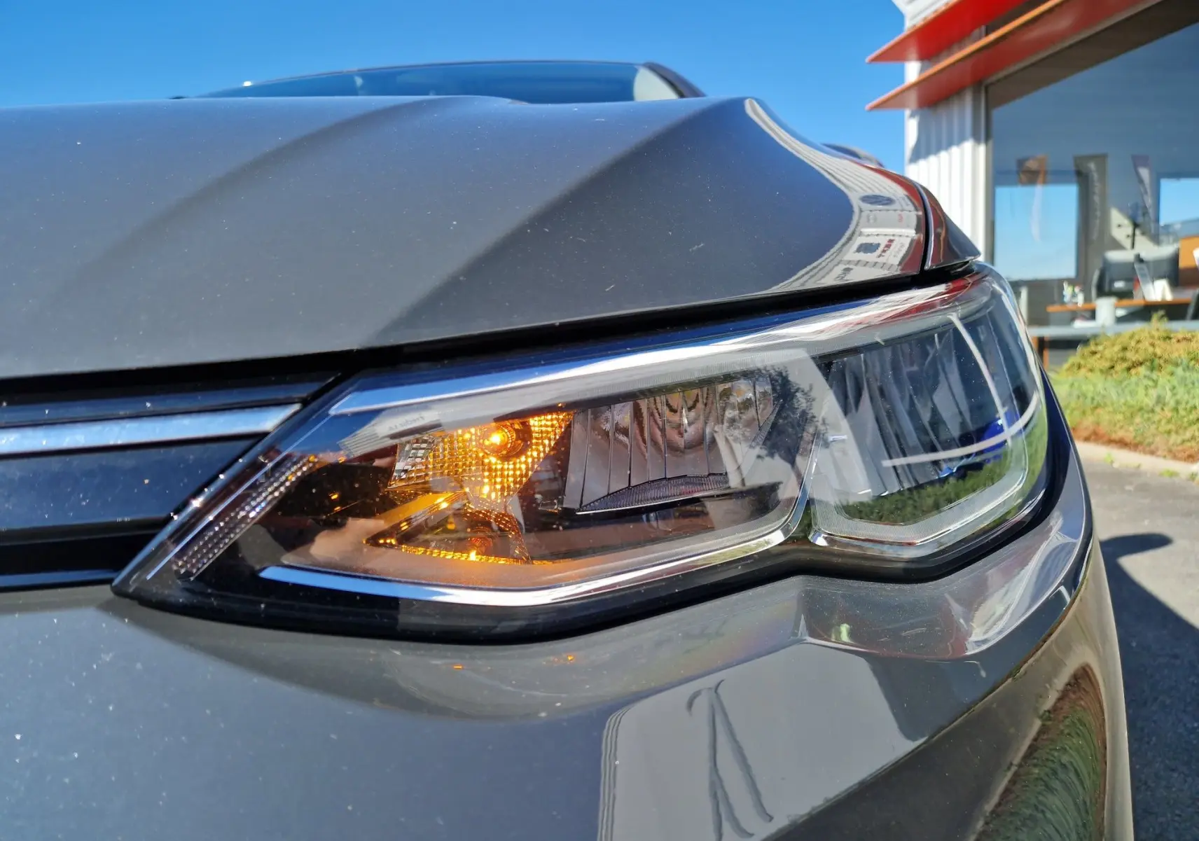 Gros plan sur le phare avant droit allumé d'une Volkswagen Golf A8 2.0 TDI gris Urano 2023.