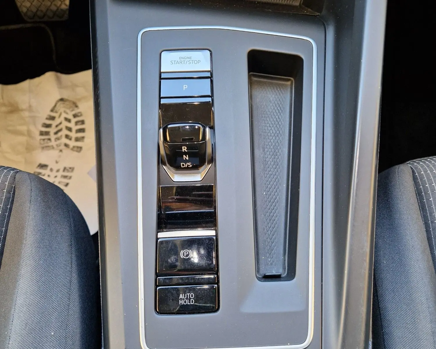 Vue en plongée sur la console centrale de la Volkswagen Golf A8 2023, avec levier de vitesses DSG et boutons de contrôle.