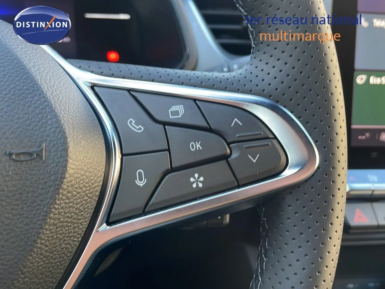 Gros plan sur les commandes du volant en cuir perforé du Renault Captur E-Tech gris cassiopée, version 2025.