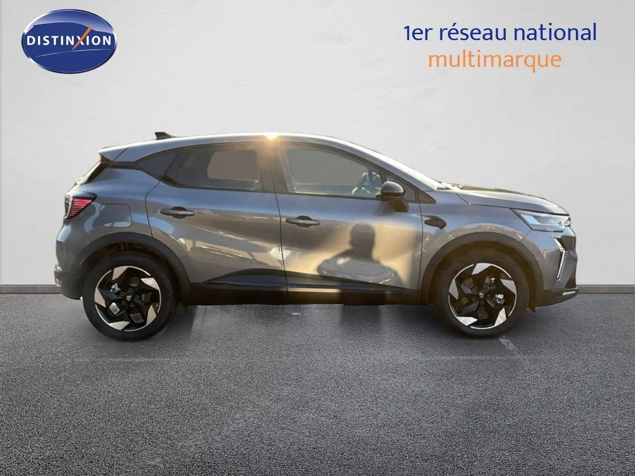 Profil droit du Renault Captur E-Tech hybride gris cassiopée métal avec jantes noires et toit noir contrasté.