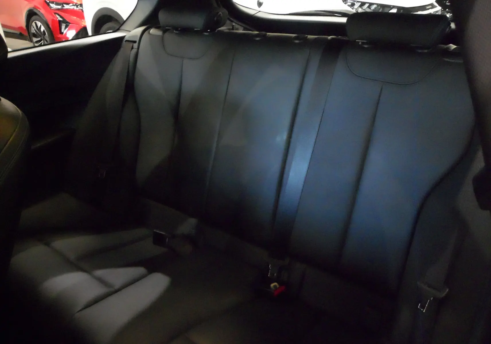 Vue intérieure sur la banquette arrière en cuir noir de la BMW Série 1 F21 LCI 118i gris, finition M Sport Ultimate.