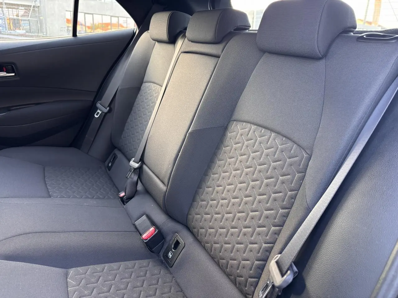 Vue intérieure sur les sièges arrière noirs avec motifs géométriques de la Toyota Corolla Hybride 2020.