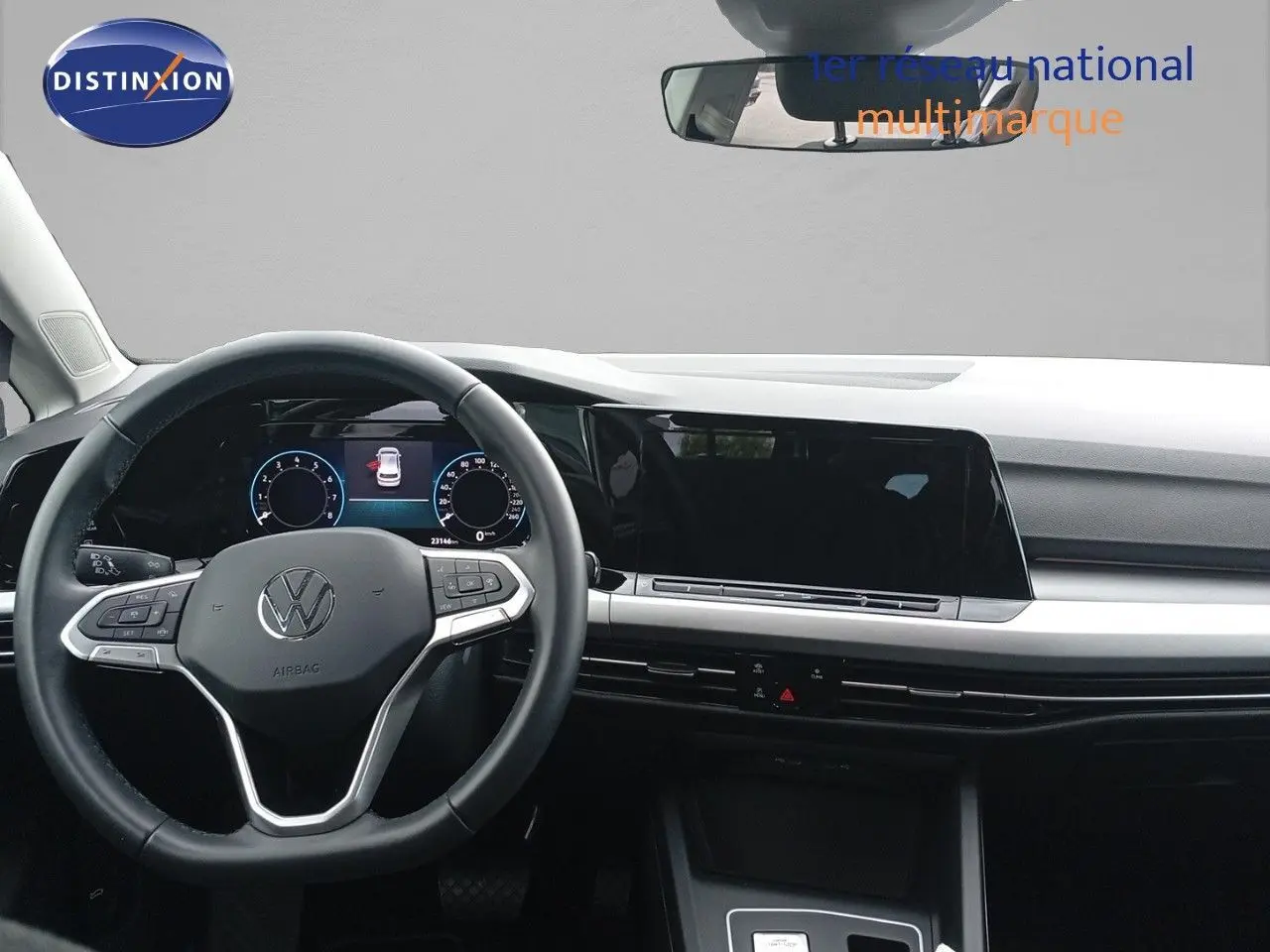 Vue intérieure frontale du tableau de bord et volant noir de la Volkswagen Golf VIII bleu Atlantique métal de 2023.