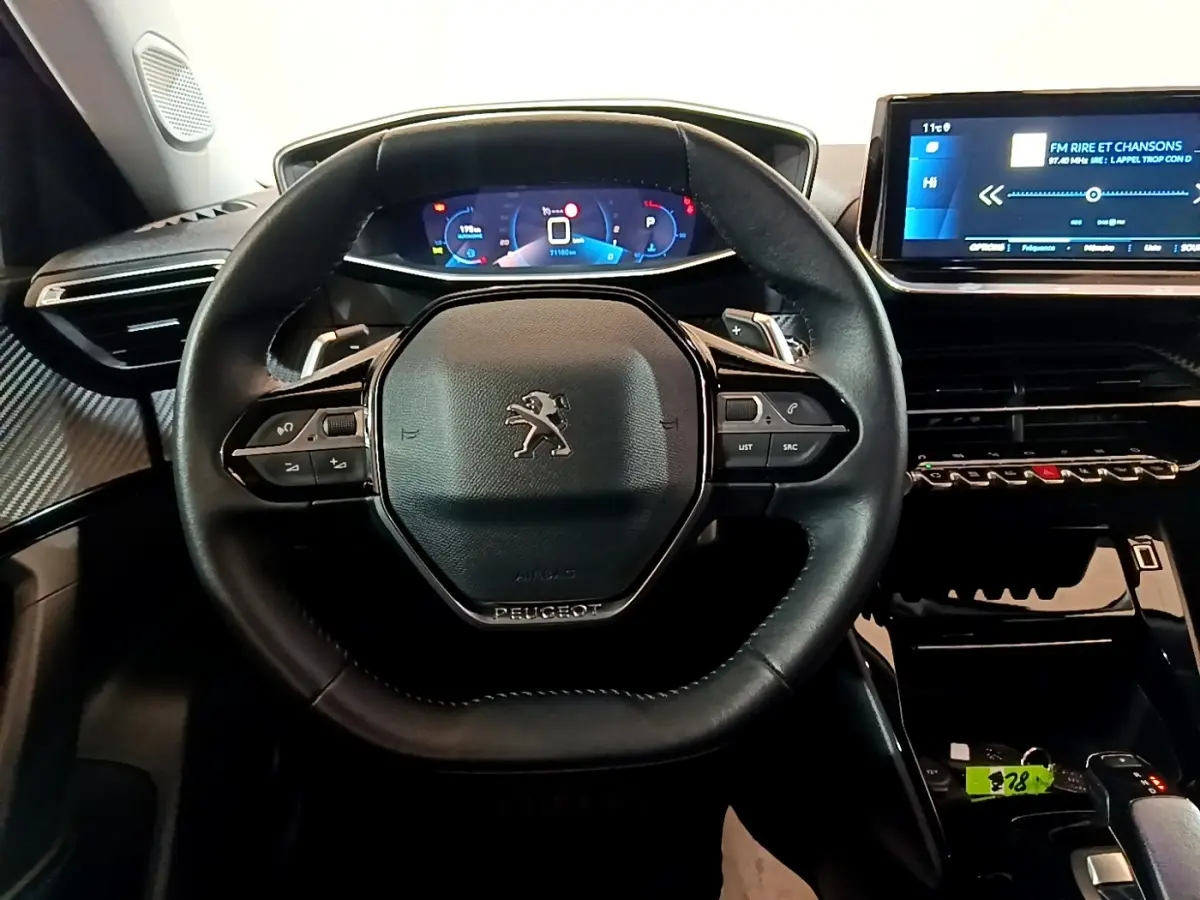 Vue rapprochée du volant cuir noir et du tableau de bord numérique bleu du Peugeot 2008 version 2021.