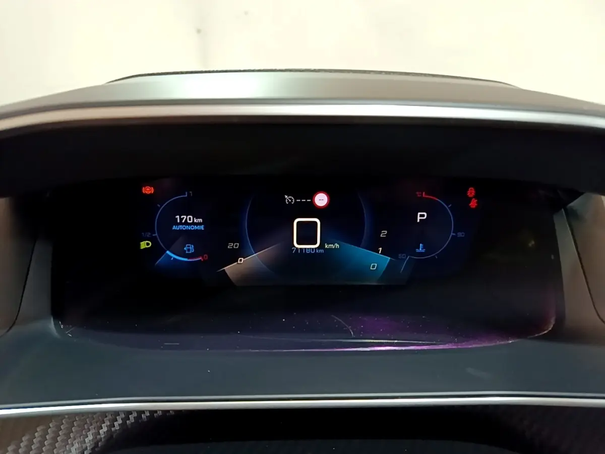 Affichage numérique du tableau de bord du Peugeot 2008 noir, montrant l'autonomie et la vitesse à l'arrêt.