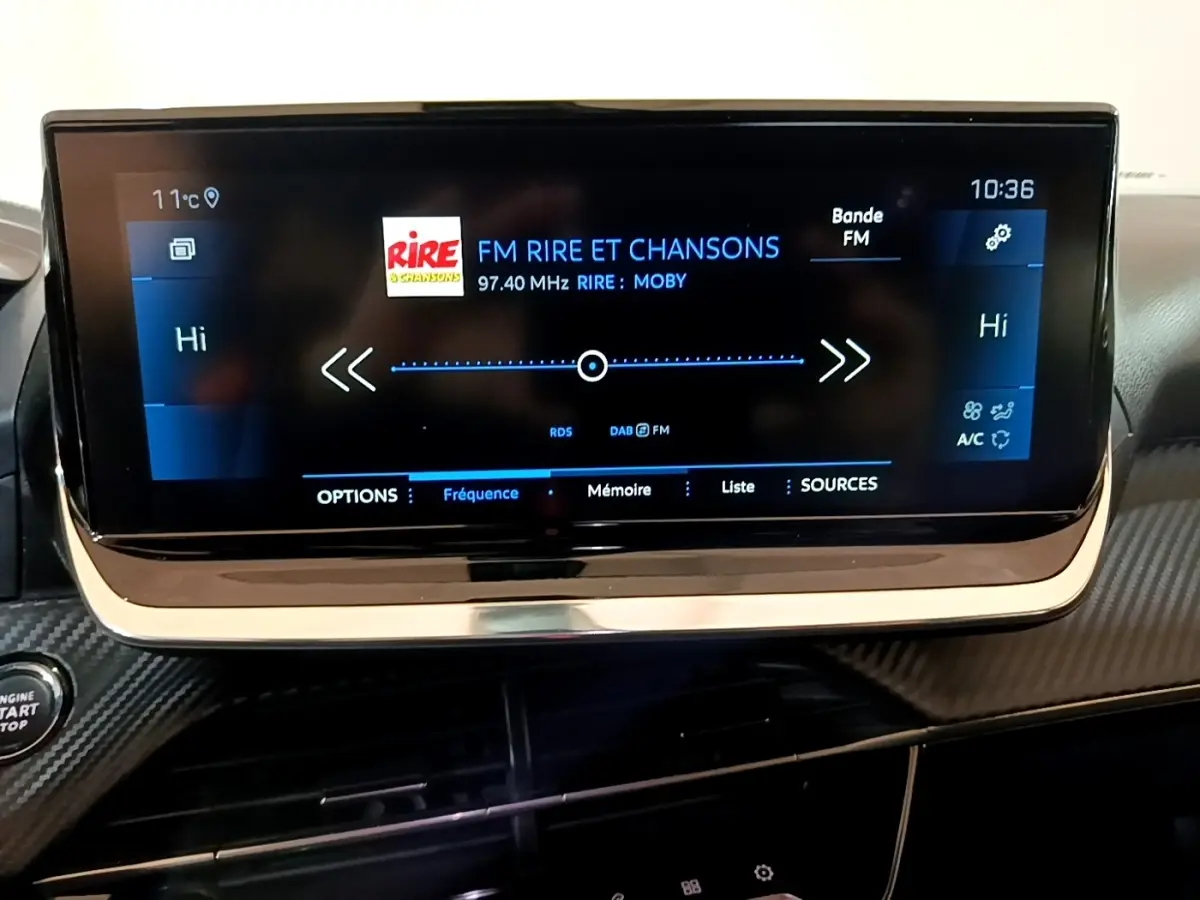 Écran tactile central affichant la radio FM dans l'habitacle noir du Peugeot 2008 BlueHDi 130, vue de face.