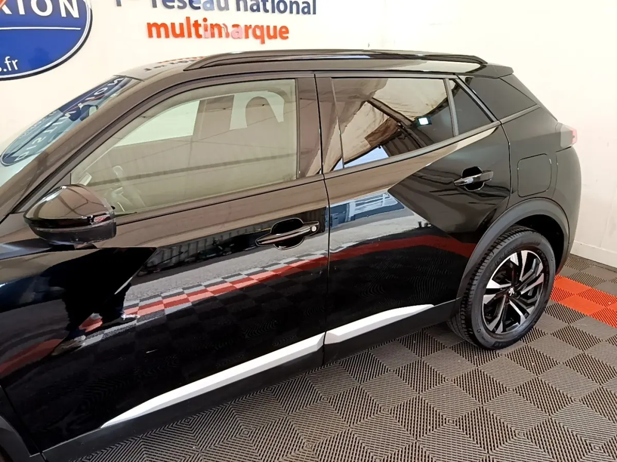 Profil côté gauche du Peugeot 2008 noir 2021, mettant en valeur les lignes sculptées et les jantes alliage noires.