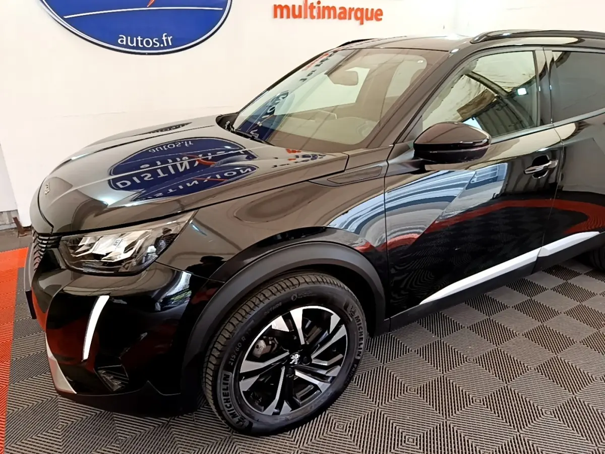 Peugeot 2008 noir en 3/4 avant droit, avec jantes alliage noires et feux LED distinctifs allumés.