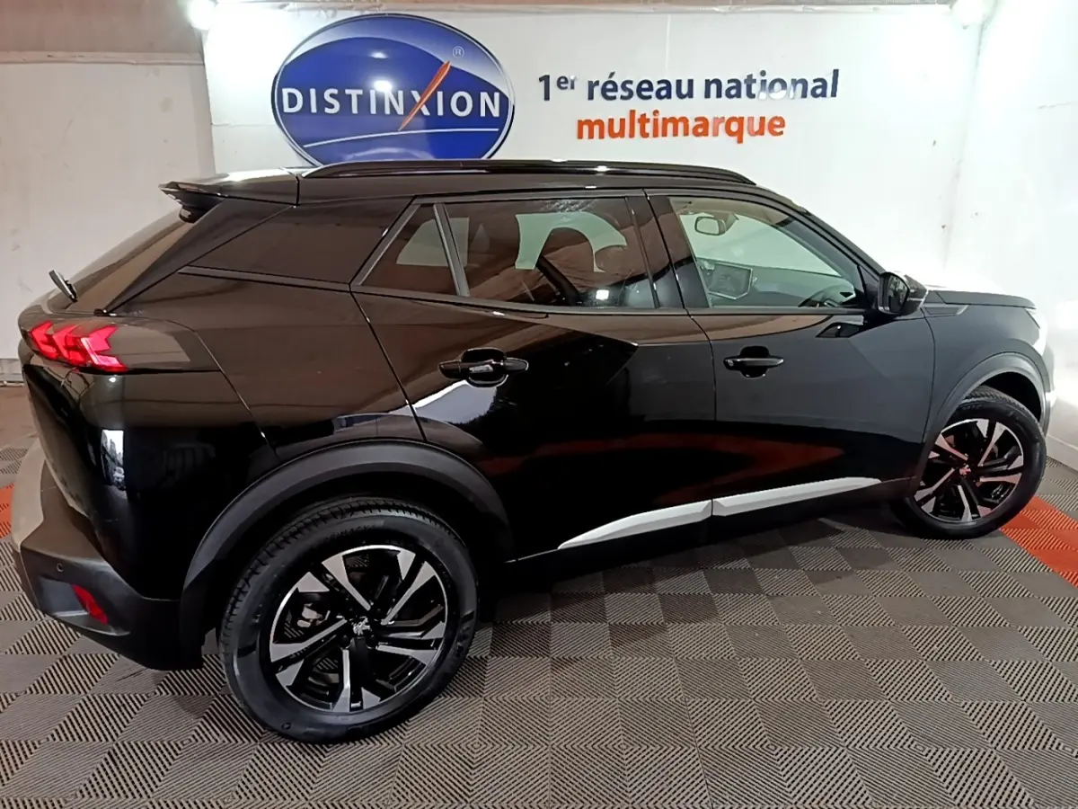 Peugeot 2008 noir vue de profil droit en intérieur, soulignant ses jantes noires et feux arrière LED distinctifs.