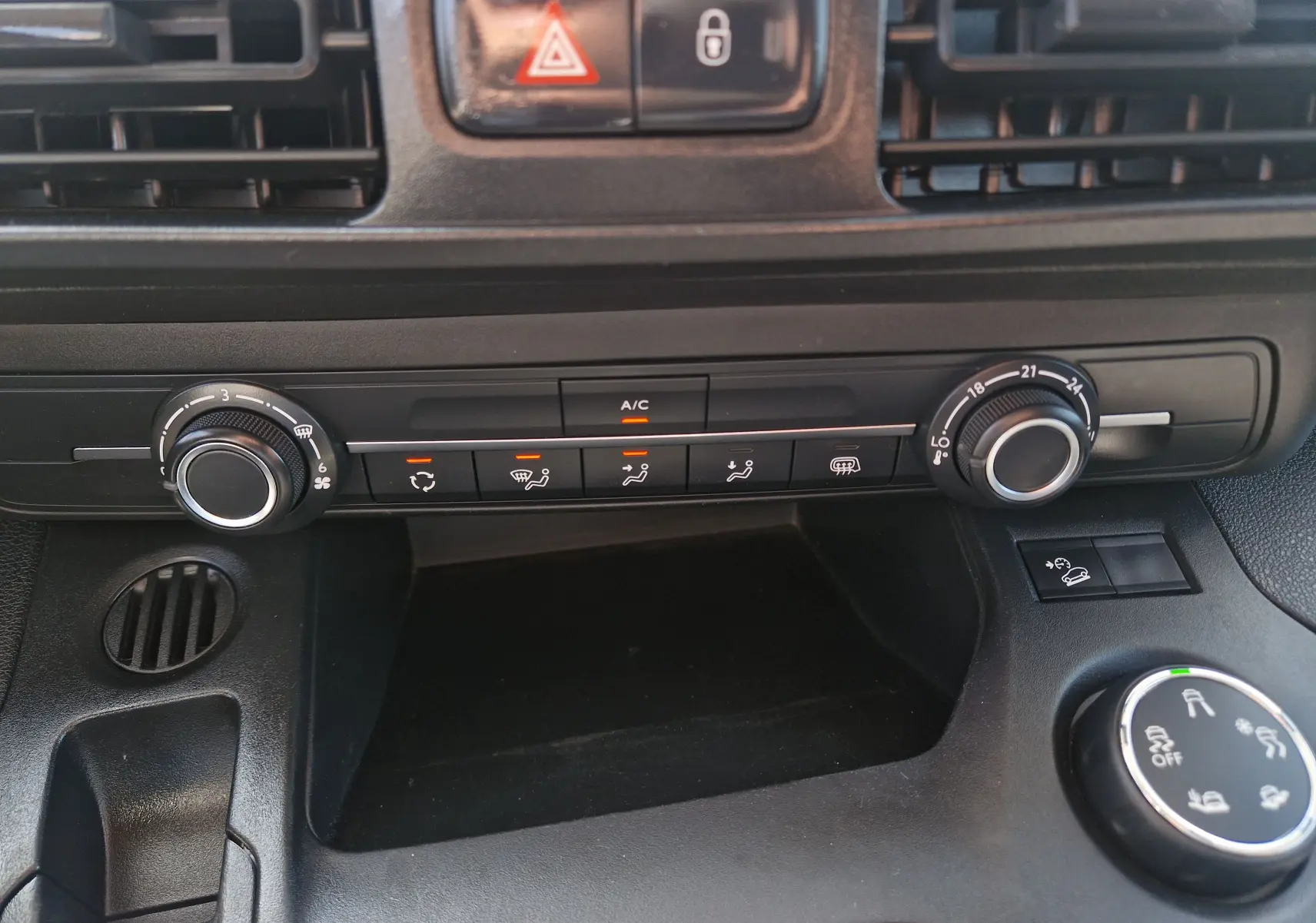 Vue rapprochée du tableau de bord noir du Citroën Berlingo 2020, montrant les commandes de climatisation et ventilation.