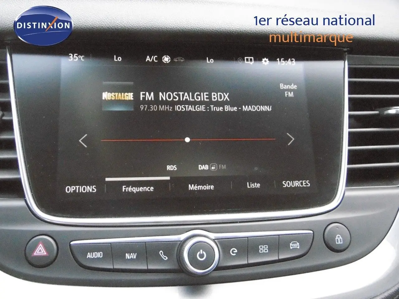 Écran tactile central du tableau de bord de l'Opel Grandland X gris Himalaya, affichant la radio FM Nostalgie.