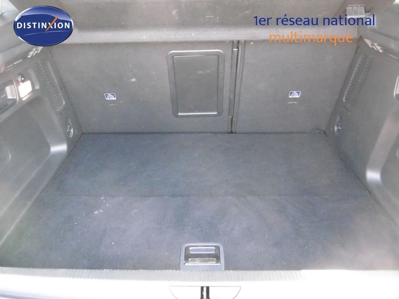 Coffre spacieux de l'Opel Grandland X hybride rechargeable, revêtement noir et compartiments intégrés.