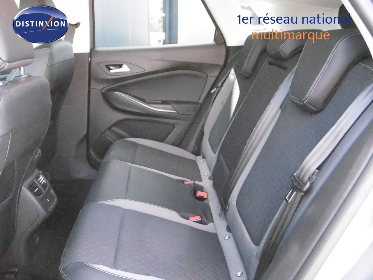 Vue latérale intérieure arrière montrant les sièges en cuir noir et tissu gris du Grandland X hybride rechargeable 2021