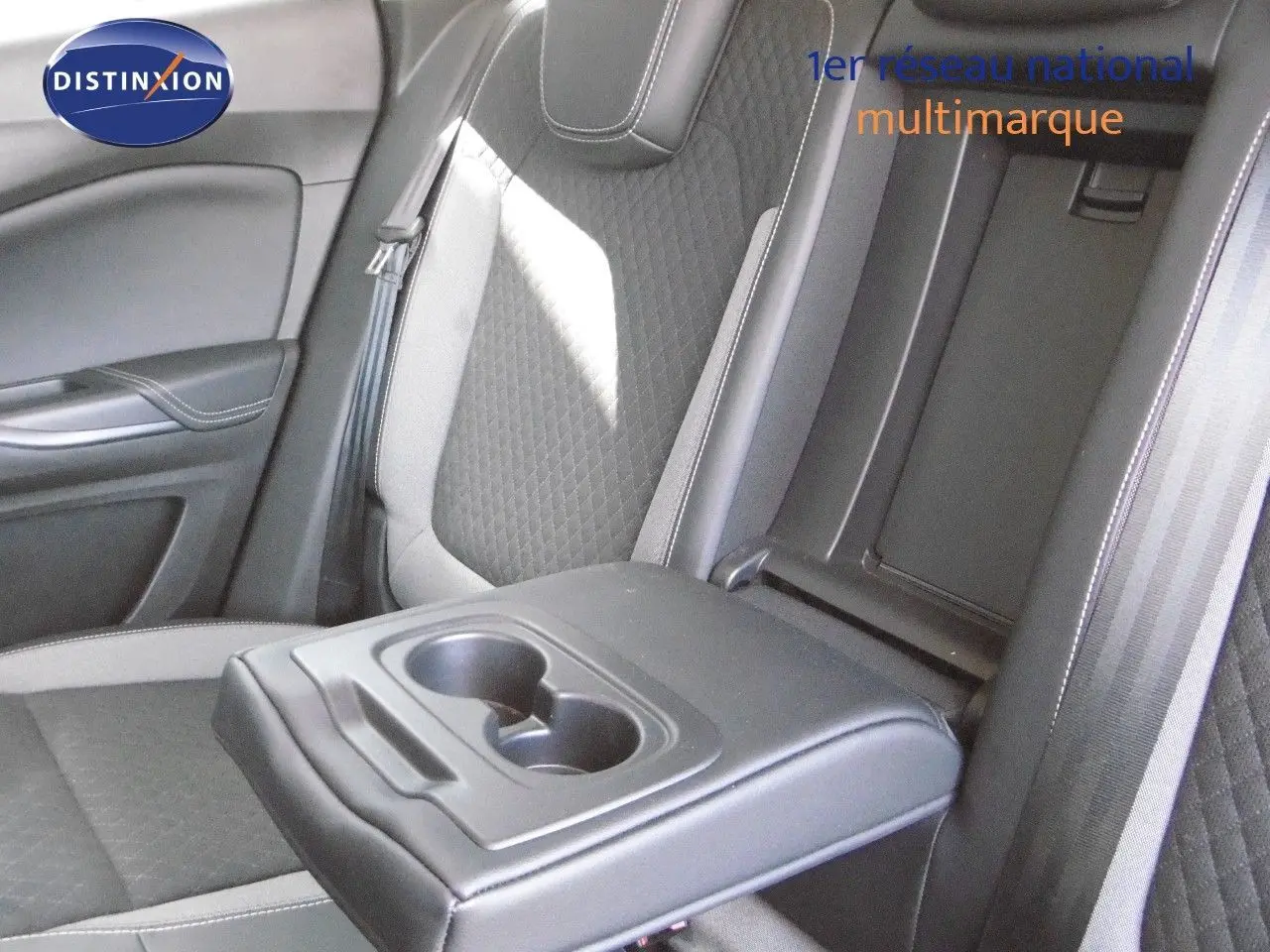 Vue rapprochée de l'accoudoir central arrière avec porte-gobelets dans l'habitacle gris et noir de l'Opel Grandland X.